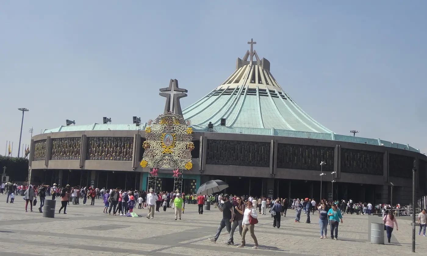 The round modern Basilica of Our Lady of Guadalupe and its plaza, with pilgrims crossing in the sun